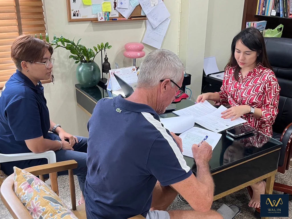 Walin reviewing paperwork with clients at the office