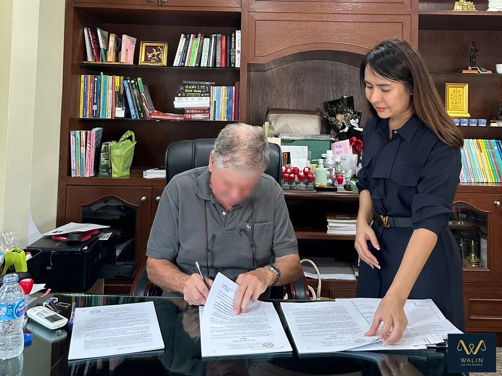 Walin assisting a client as documents are signed at the office.