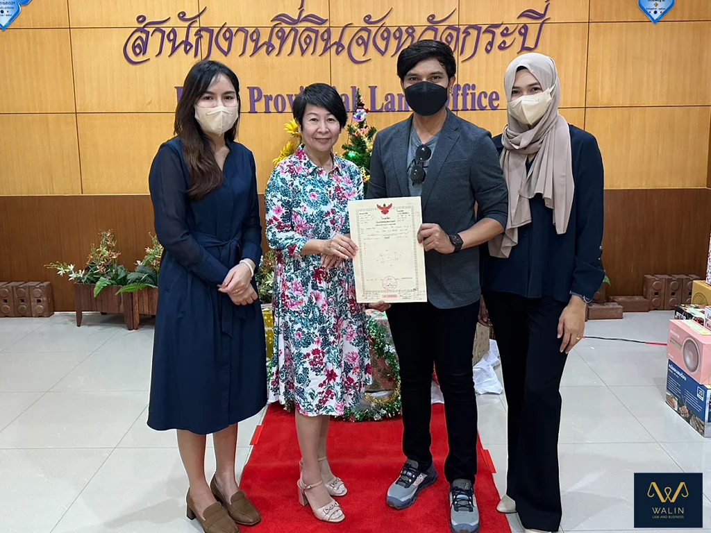 Walin with clients and a property document at the Krabi Provincial Land Office.